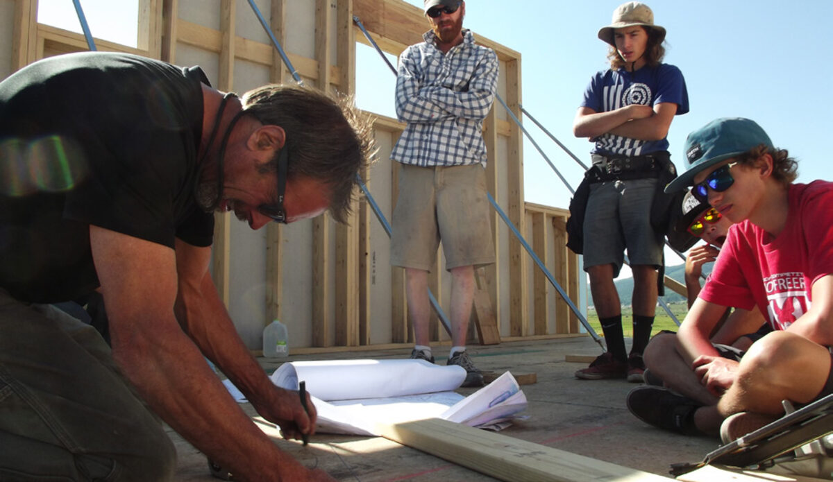 A carpenter teaching students on the framing deck